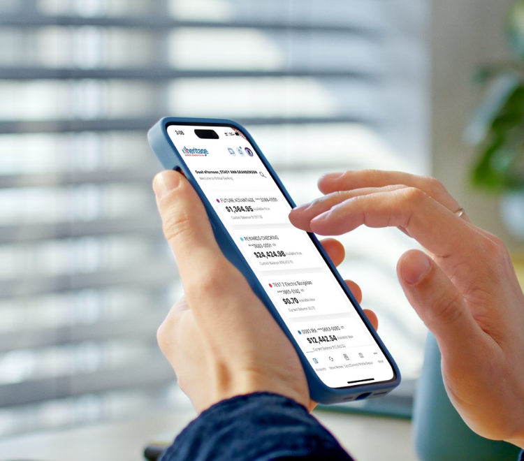Man holds phone with a blue case checking his Heritage accounts in his Heritage Digital Banking App.