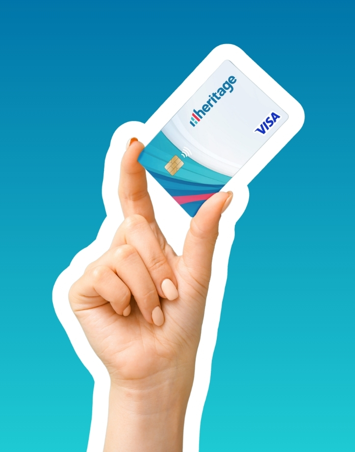 Woman's hand holding a Heritage VISA card